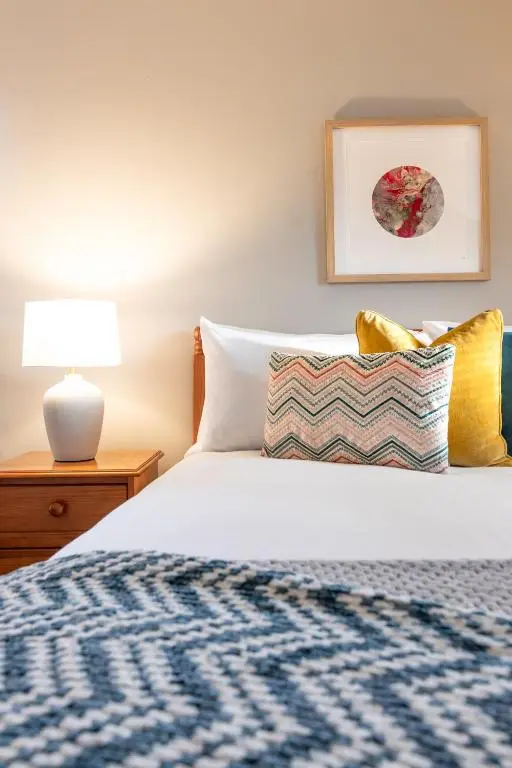 a bedroom with a bed and a lamp on a table at Sweet Ness River Flat in Inverness