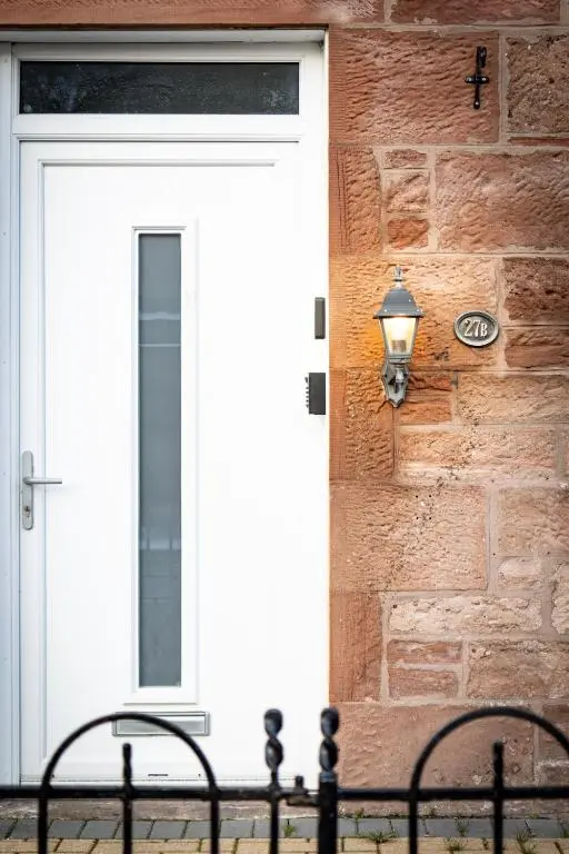a door to a house with a lamp on it at Sweet Ness River Flat in Inverness