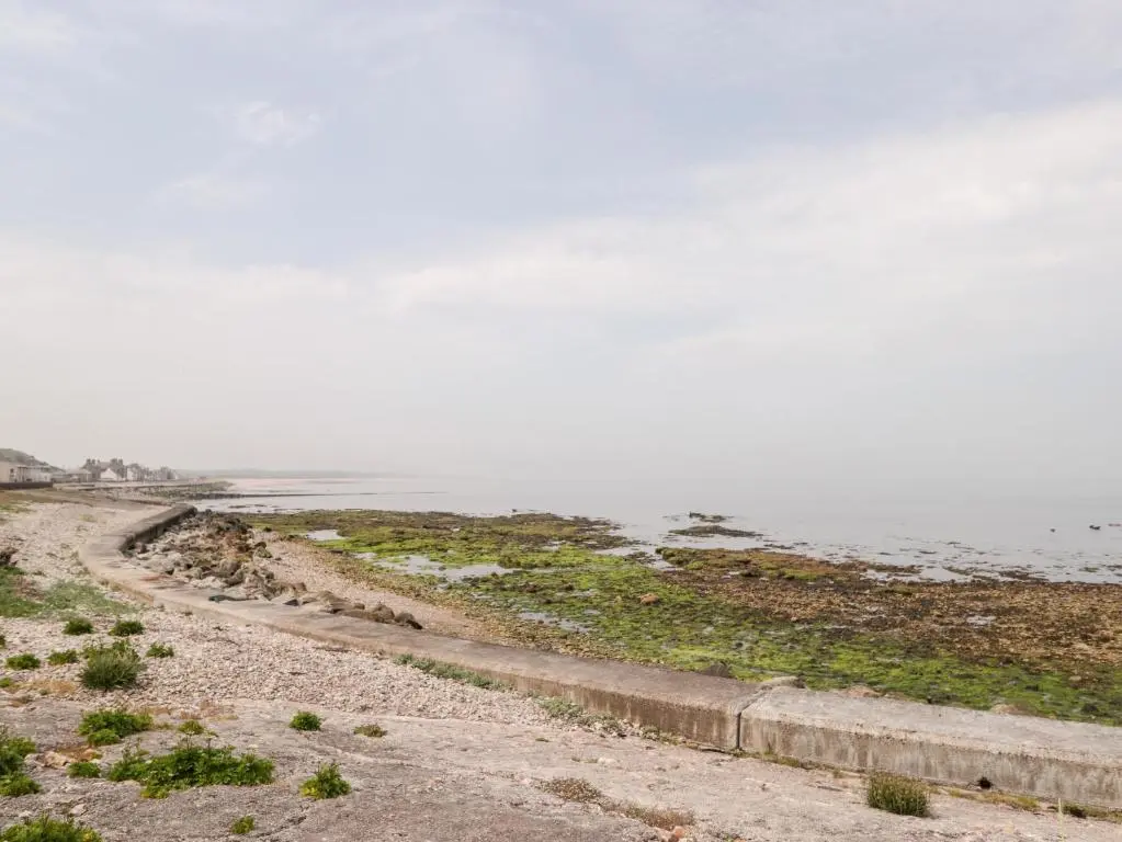 a dirt road next to a body of water at Corner Cottage in Buckie