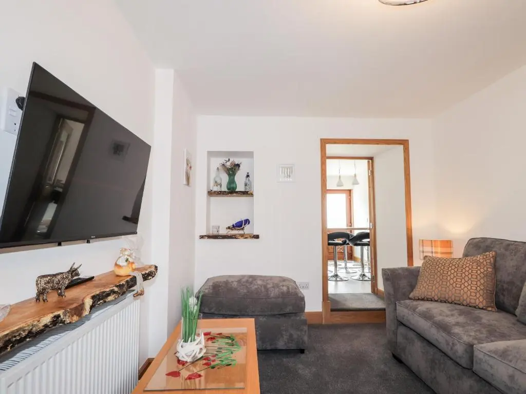 a living room with a couch and a tv at Corner Cottage in Buckie