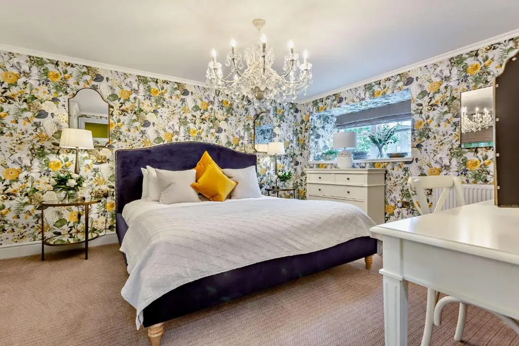 a bedroom with a bed and a chandelier at Cathedral House in Dornoch