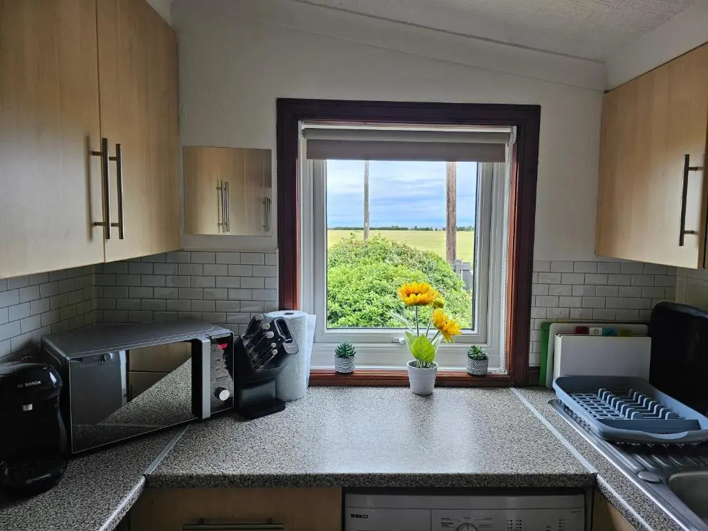 a kitchen with a window with a view of a field at Westview in Buckie
