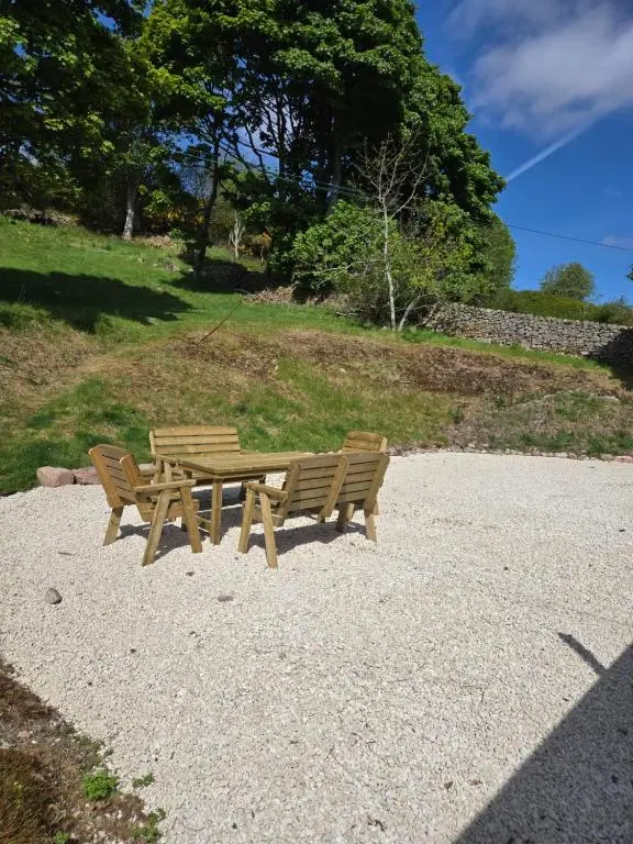 two wooden benches sitting next to a picnic table at 176 Marrell in Helmsdale