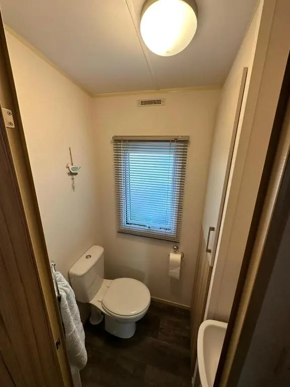 a small bathroom with a toilet and a sink at Beach life in Lossiemouth