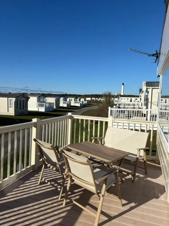 a patio with a table and chairs on a deck at Beach life in Lossiemouth