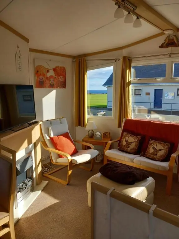 a living room with a couch and a television at Melody Brooks Caravan Park Caravan number 22 in Portknockie