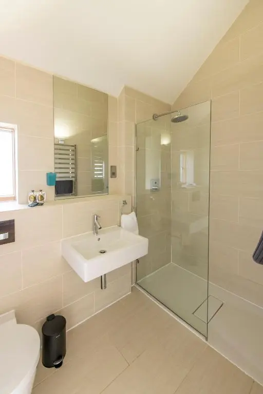 a bathroom with a sink and a shower at Architect Designed Lodge in Dunecht