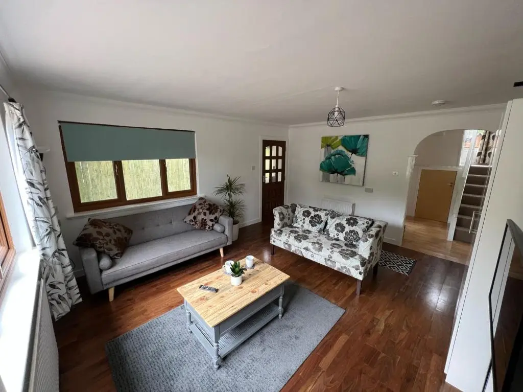 a living room with a couch and a table at Birchwood Cottage in Tore