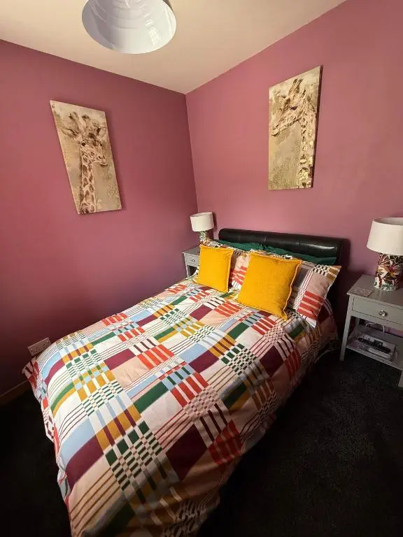 a bedroom with a colorful bed with yellow pillows at Old Dairy in Tain