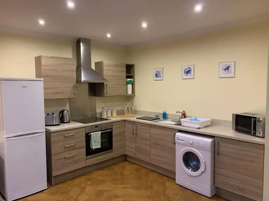 a kitchen with a washing machine and a washer at The old post office in Golspie