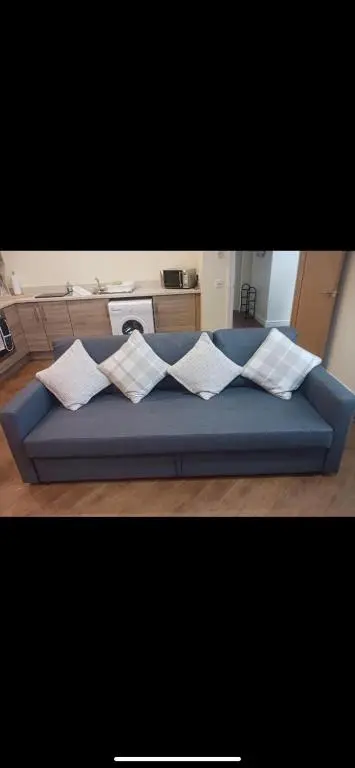 a blue couch with pillows on it in a room at The old post office in Golspie