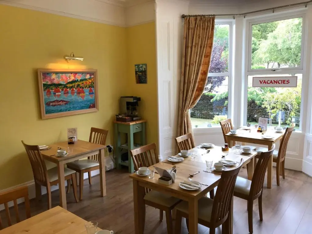 a dining room with tables and chairs and a window at West End Guest House in Elgin