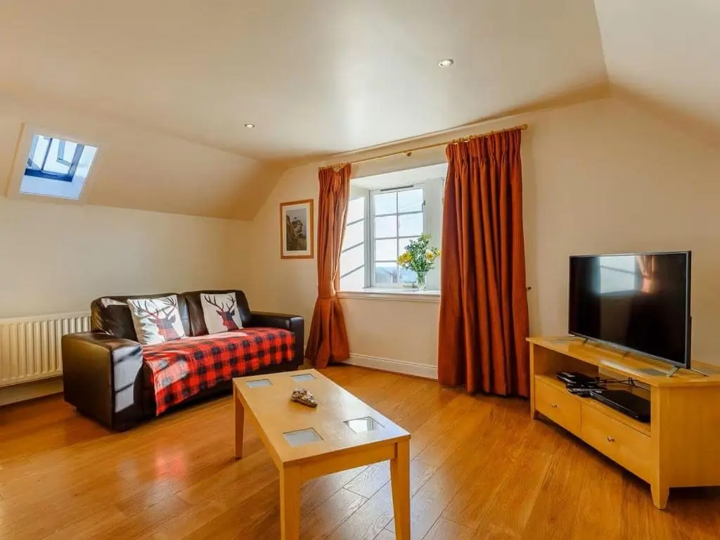 a living room with a couch and a tv at Craiglea Barn in Latheron