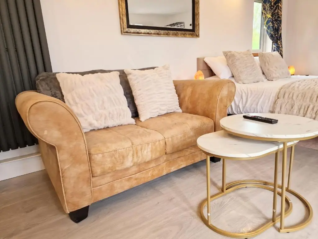 a living room with a couch and a table at Kaoglen Buck Pod - Hot Tub - Dog Friendly in Blairgowrie