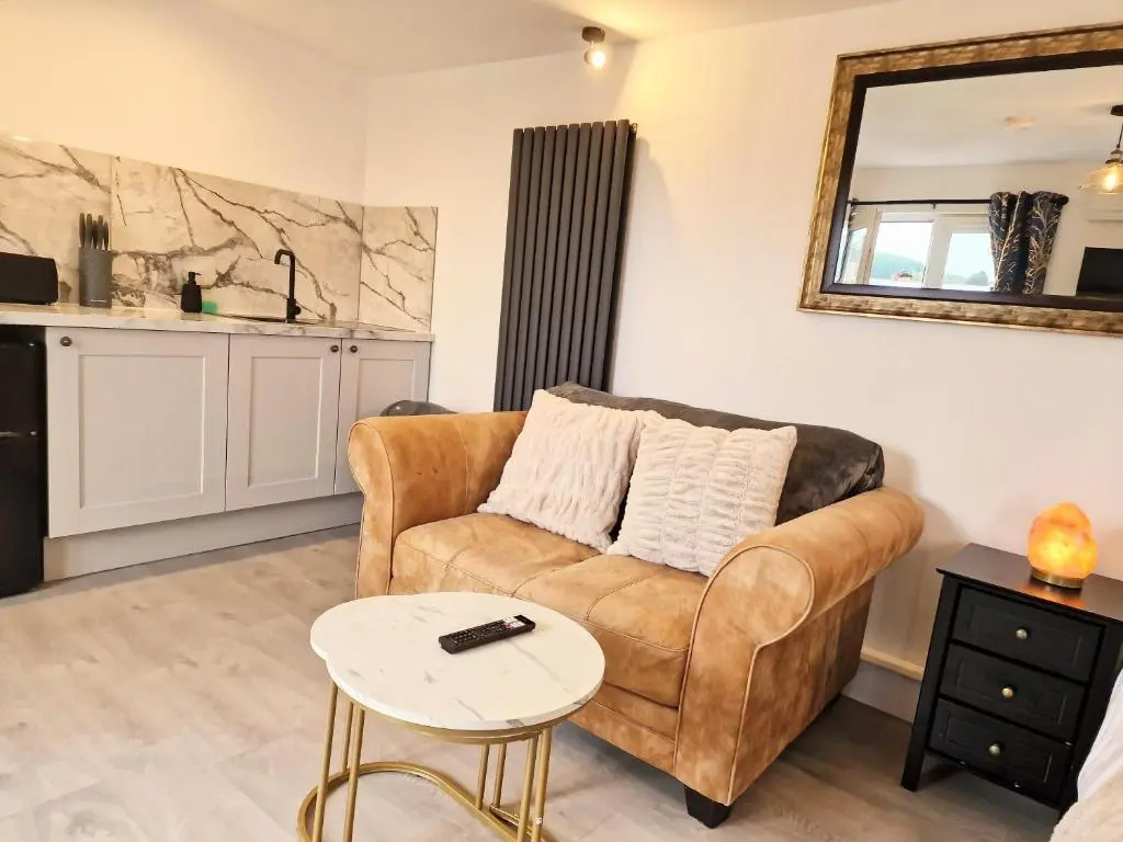 a living room with a couch and a table at Kaoglen Buck Pod - Hot Tub - Dog Friendly in Blairgowrie