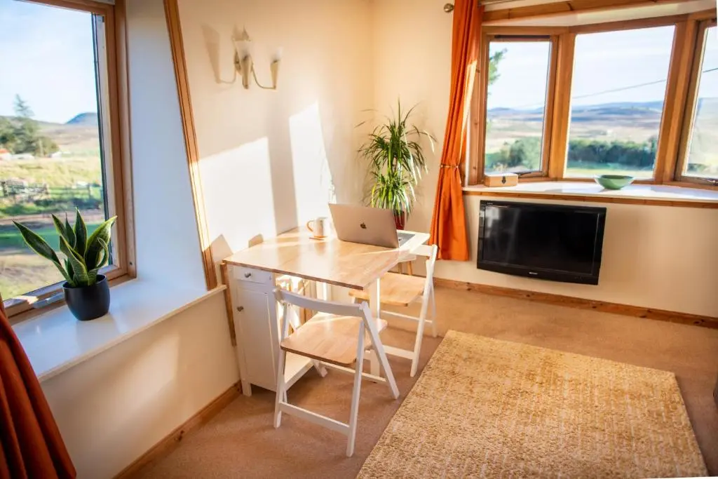 a small room with a table and a laptop on it at The High Croft in Rogart