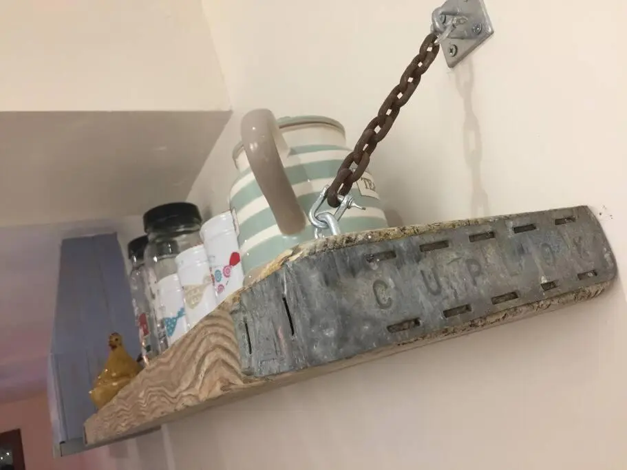a metal object hanging on a wall with a chain at Upper Corronich in Boat of Garten