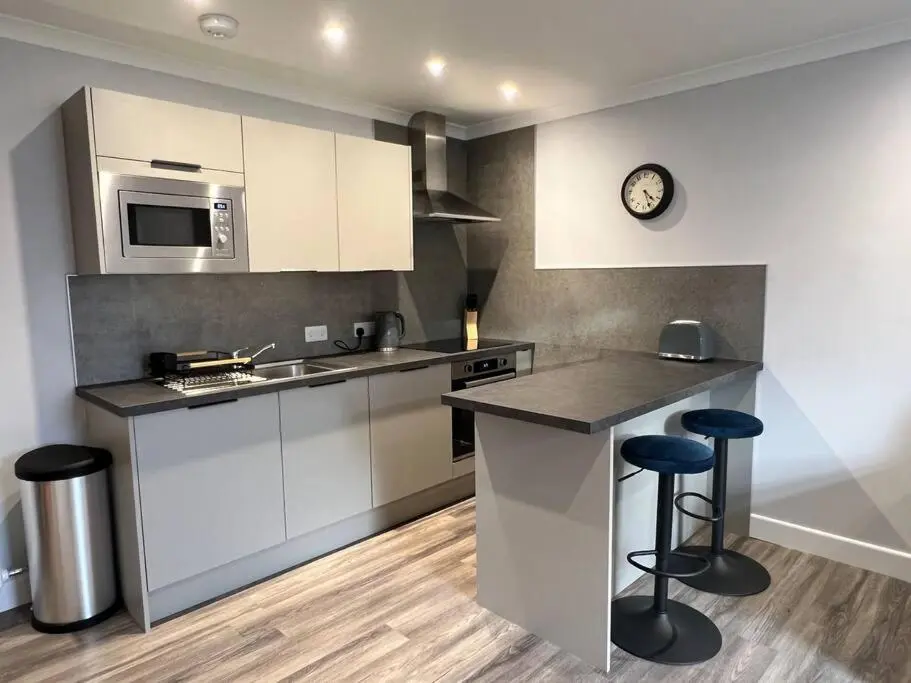 a kitchen with a counter and stools in it at Kingsmills Apartment in Inverness