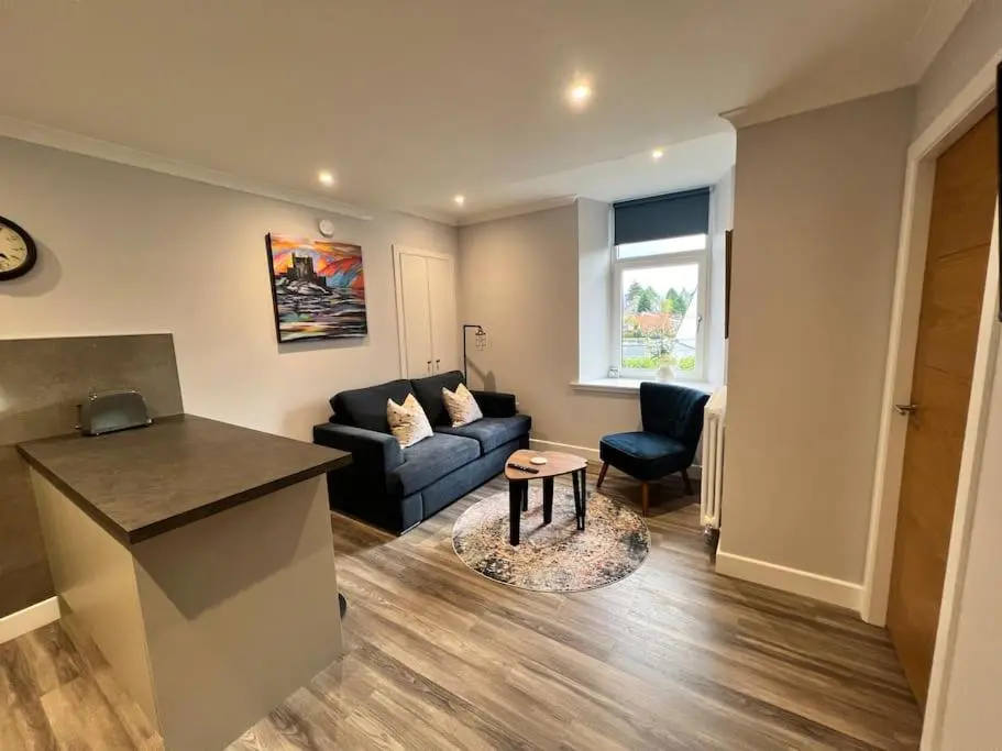 a living room with a couch and a table at Kingsmills Apartment in Inverness