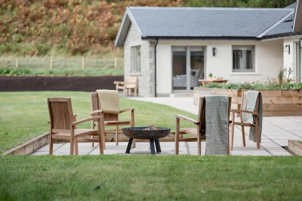 a group of chairs and a fire pit in a yard at Culfoichbeg Lodge - Seasgair Lodges in Grantown on Spey
