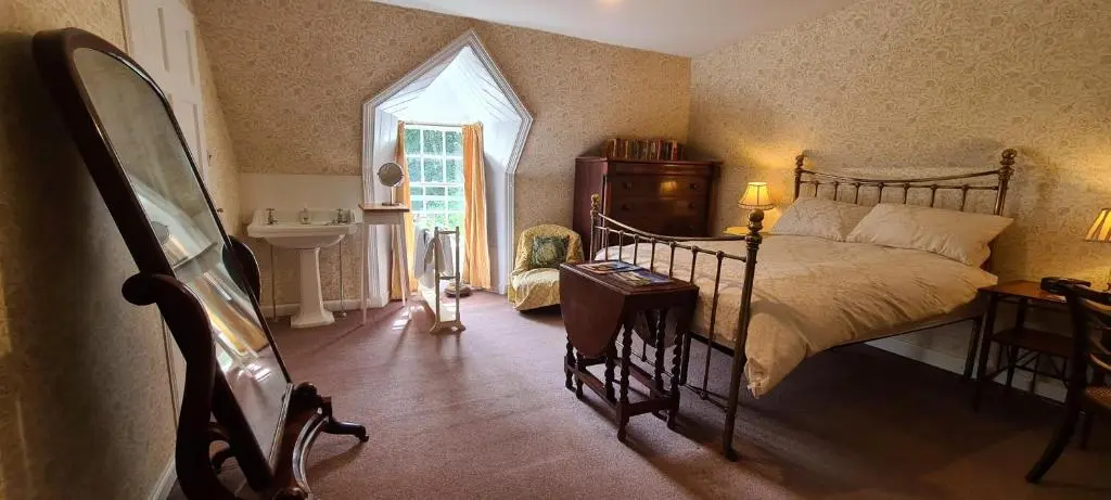 a bedroom with a bed and a sink and a window at Thrumster House in Wick