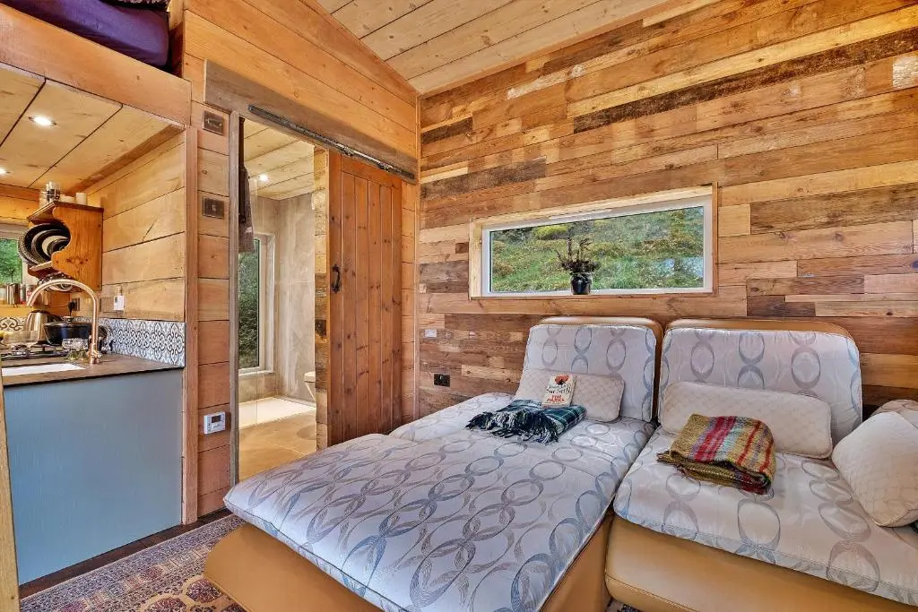 a small bedroom with a couch in a tiny house at Finest Retreats - Cosagach Falls Cabin in Kiltarlty