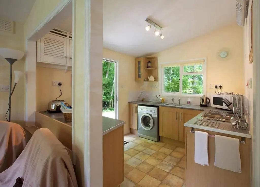 a kitchen with a sink and a washing machine at Satchwell Chalet on Reelig Estate - Dog Friendly in Kirkhill