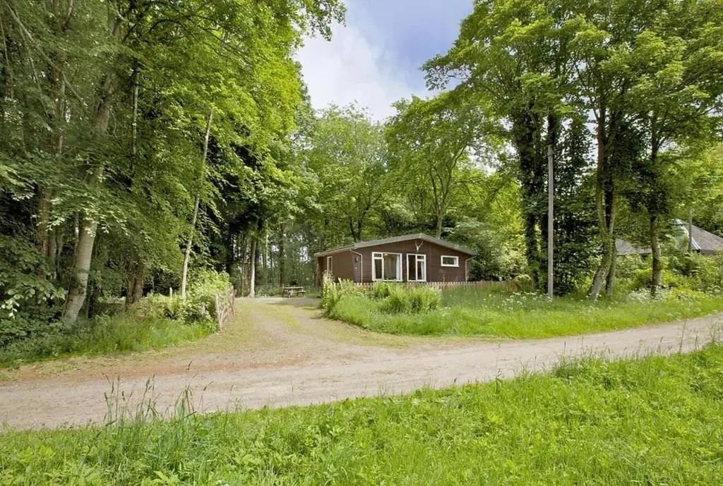 a small house on the side of a dirt road at Satchwell Chalet on Reelig Estate - Dog Friendly in Kirkhill