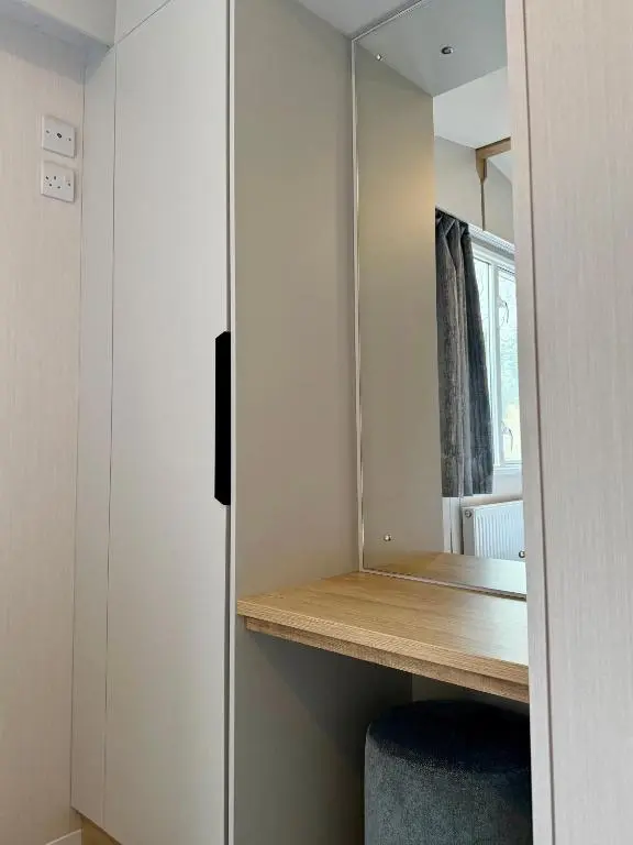 a small room with a desk and a mirror at The Malt Van - Beautiful, luxury static caravan in Aberlour