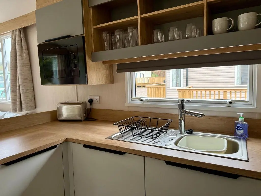a kitchen with a sink and a window at The Malt Van - Beautiful, luxury static caravan in Aberlour