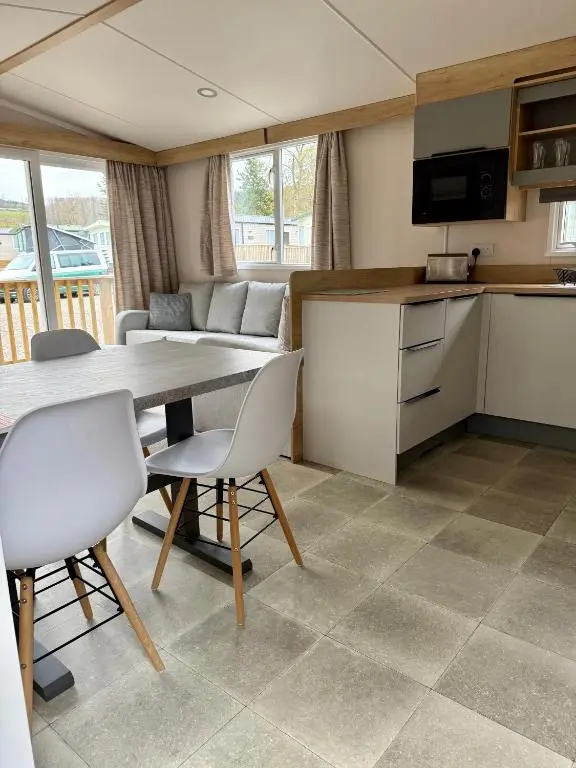 a kitchen and living room with a table and chairs at The Cooper's Van - Beautiful, luxury static caravan in Aberlour