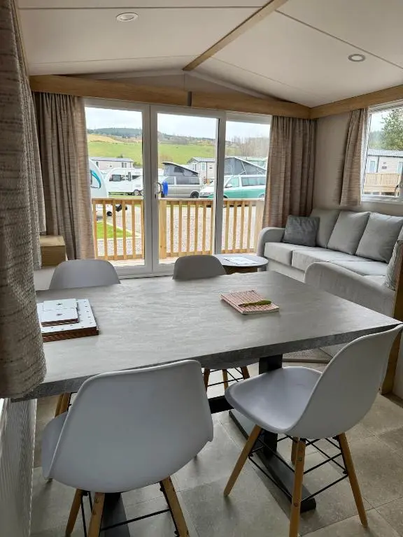 a living room with a large table and chairs at The Cooper's Van - Beautiful, luxury static caravan in Aberlour