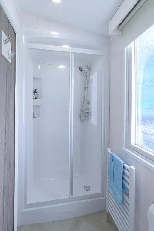a bathroom with a shower with a glass door at The Distiller\u2019s Van - Beautiful, luxury static caravan in Aberlour