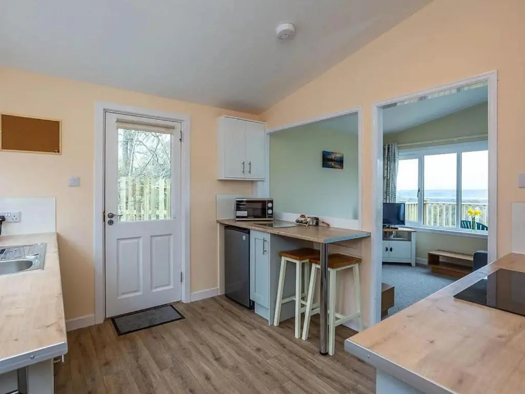 a kitchen with a table and a counter top at Kilninver Chalet on Reelig Estate in Kirkhill