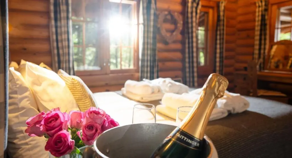 a bottle of champagne and flowers on a table at Beaver Creek Lodge in Aviemore