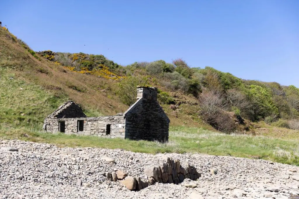 an old stone house sitting on a hill at Craiglea Lodge in Latheron