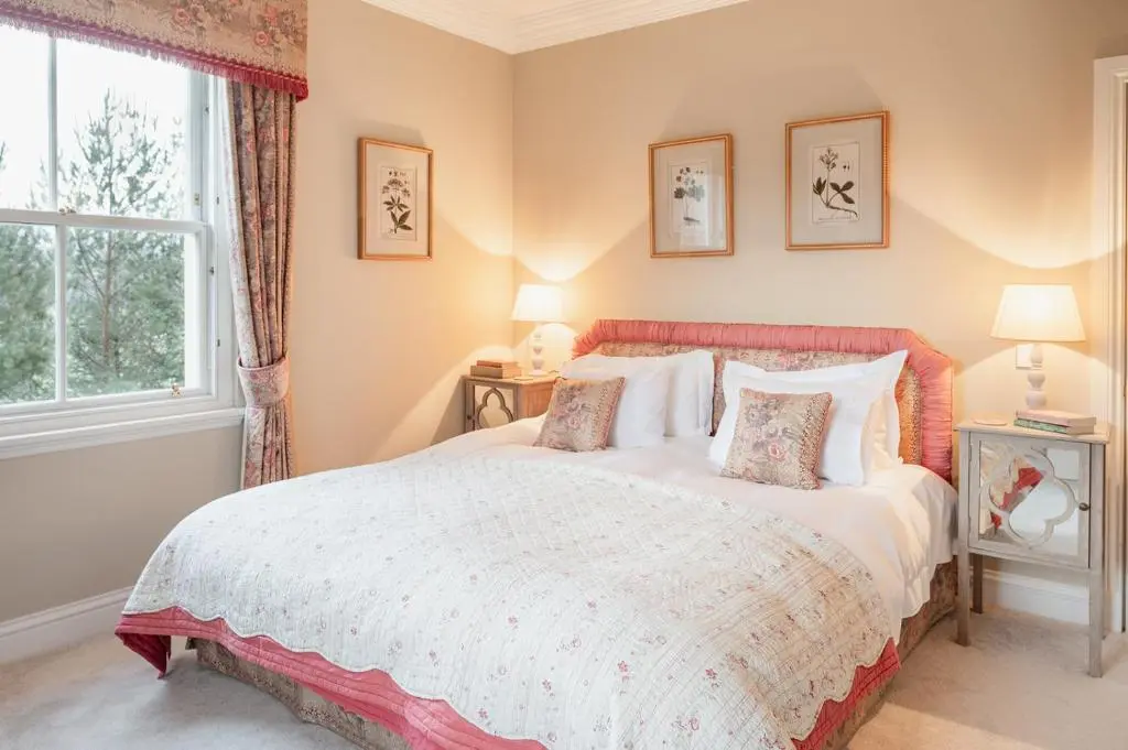 a bedroom with a large bed and a window at Milton Lodge - Seasgair Lodges in Newtonmore