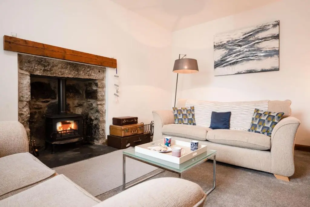 a living room with two couches and a fireplace at Douglas Cottage - Seasgair Lodges in Boat of Garten