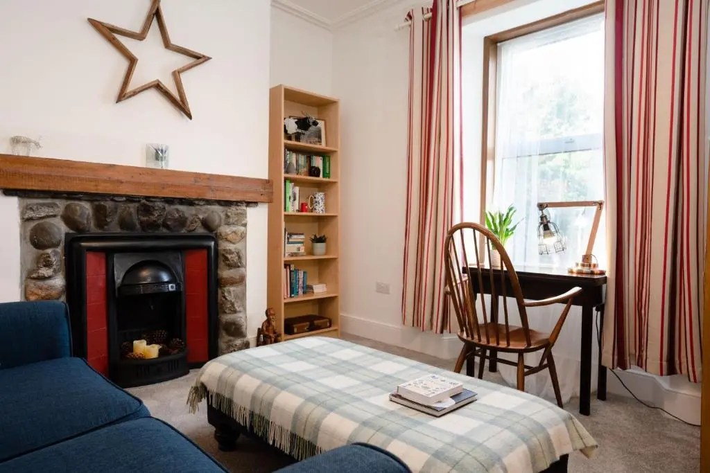 a living room with a couch and a fireplace at Douglas Cottage - Seasgair Lodges in Boat of Garten