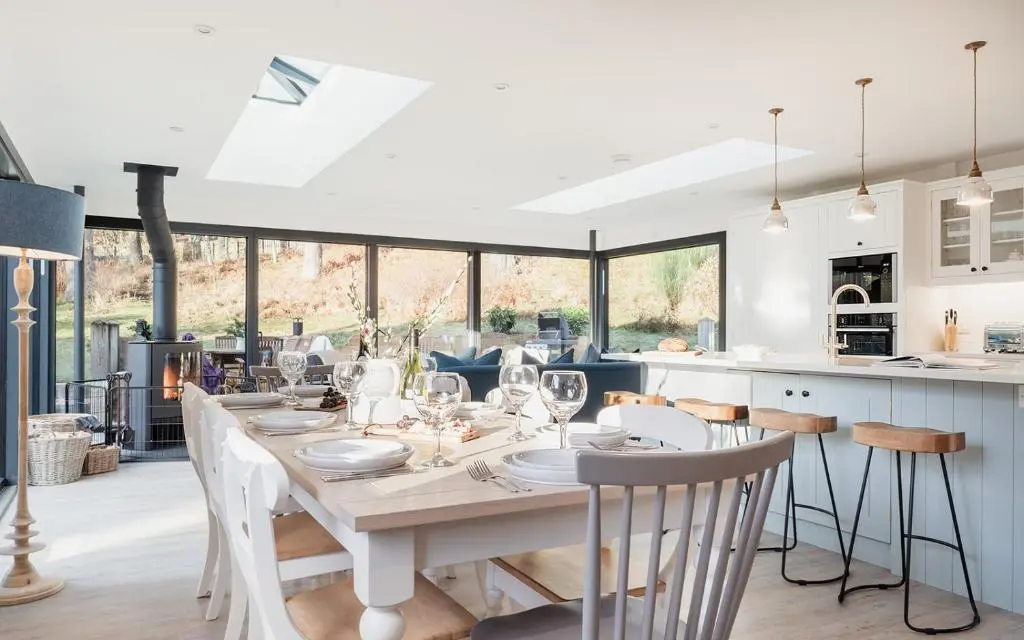 a kitchen and dining room with a table and chairs at Oak Cottage - Seasgair Lodges in Kincraig