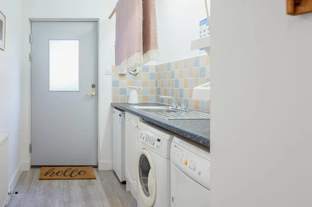 a kitchen with a washing machine and a sink at Oak Cottage - Seasgair Lodges in Kincraig