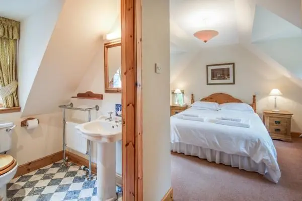 a bedroom with a bed and a sink and a toilet at Rymore Wood Lodge - Seasgair Lodges in Nethy Bridge