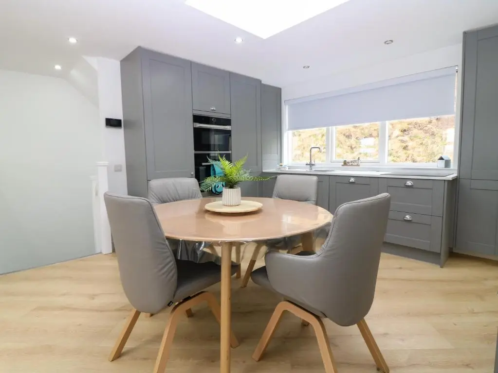 a kitchen with a wooden table and gray chairs at Craignure in Banff