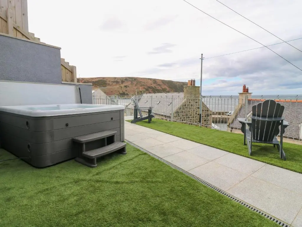 a backyard with a hot tub on the grass at Craignure in Banff