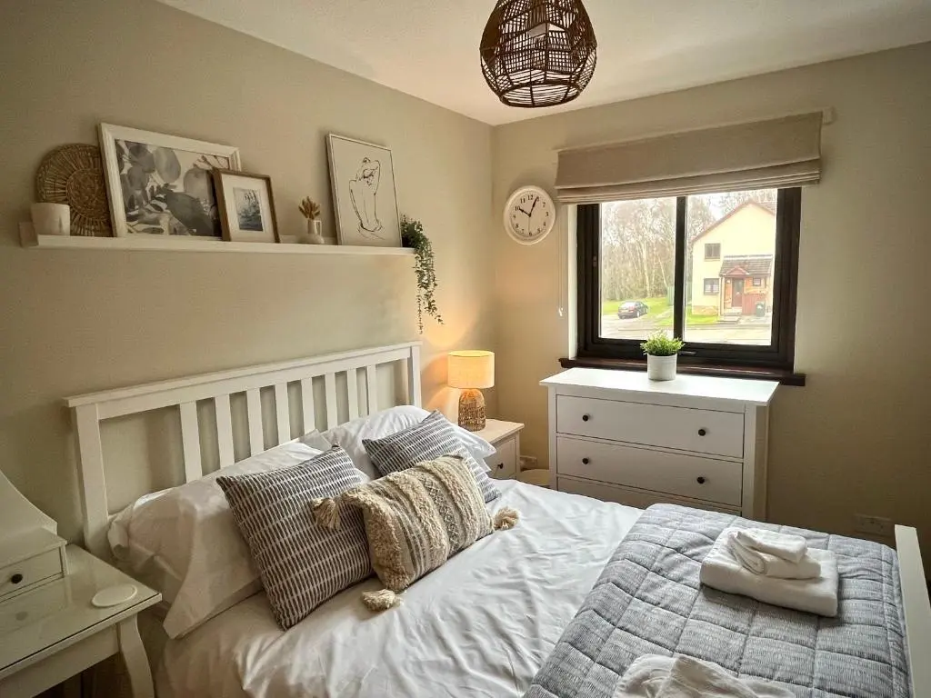 a bedroom with a bed with a teddy bear on it at Comfortable, modern apartment with parking. Inverness. in Inverness