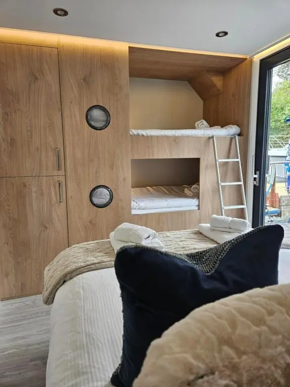 a bedroom with two bunk beds and a ladder at Caley Cruisers in Inverness