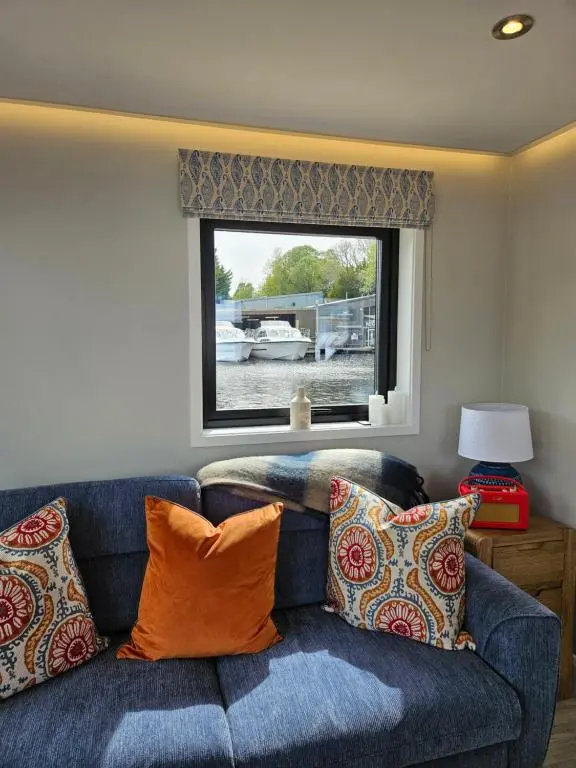 a blue couch with pillows in a room with a window at Caley Cruisers in Inverness