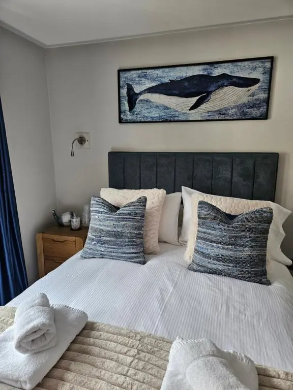 a bedroom with a bed with blue and white pillows at Caley Cruisers in Inverness