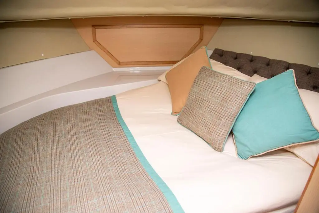 a bed in the back of a boat with two pillows at Caley Cruisers in Inverness