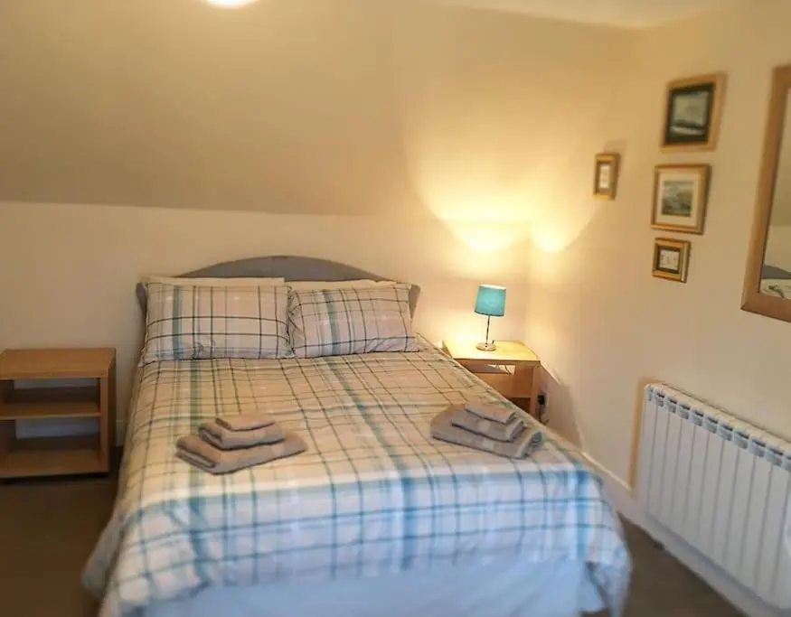 a bedroom with a bed with two towels on it at Traditional Croft Cottage Minutes from Lochness in Drumnadrochit